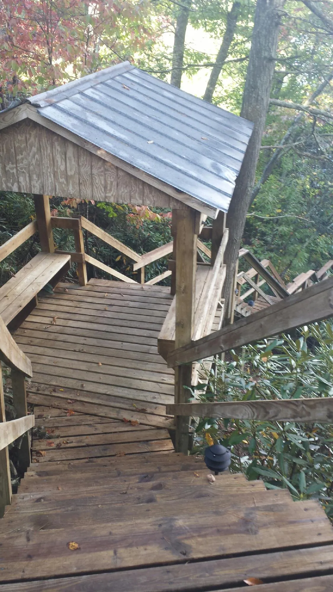 Metal roofed shelter over wooden steps on a wooded walkway — Skylight Repair & Installation work by our crew in Chatsworth